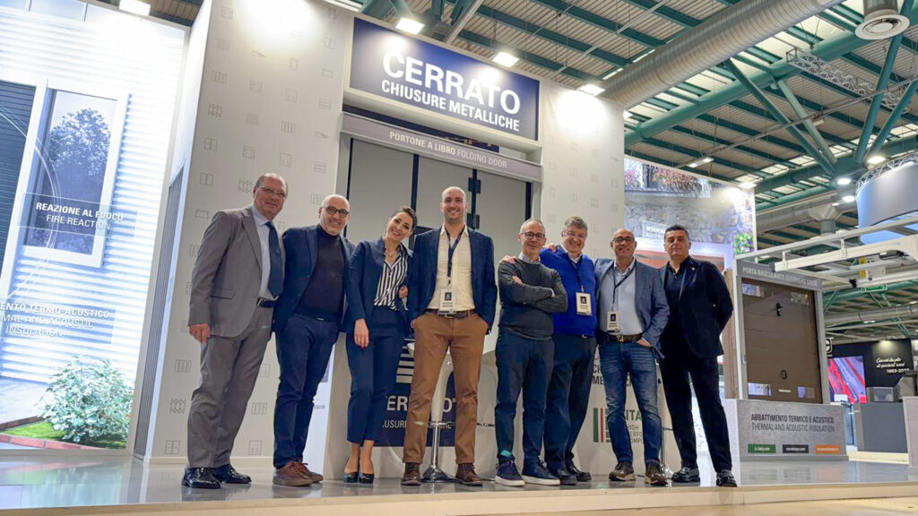 Foto di gruppo del team Cerrato Chiusure Metalliche. Alle spalle del gruppo lo stand realizzato per la fiera CaseItaly di Bergamo
